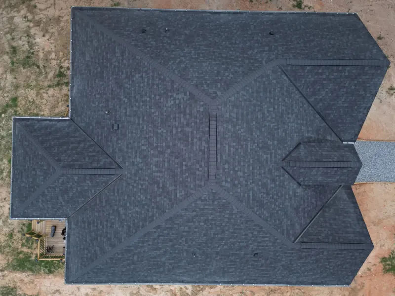 Top-down view of a gray shingle roof showing ridges, roof planes, and edges.